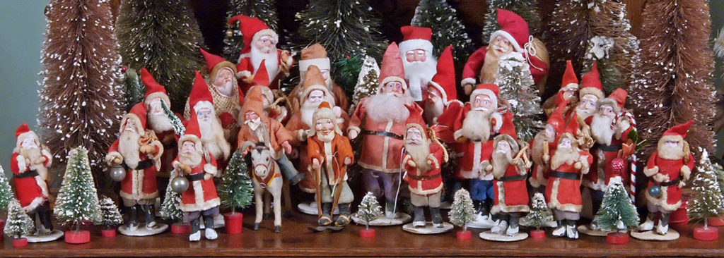 A collection of miniature antique Santa Clause figures from around the world